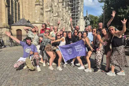 Groep vrienden geniet van een actieve groepsactiviteit met solex rijden en Silent Disco City Tour