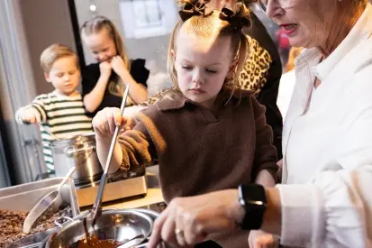 Grote groep deelnemers tijdens een kookworkshop en Bossche bollen maken.
