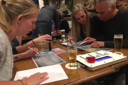 Grote zaal met tientallen deelnemers tijdens een Escape Dinner Game