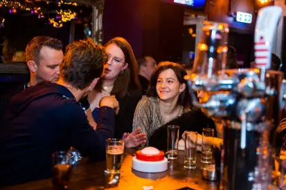 Grote groep collega's tijdens een origineel bedrijfsuitje met quiz en dinerspel of borrel